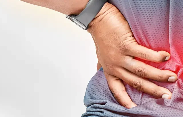Shot of an unrecognizable man standing alone outside and suffering from backache during his run
